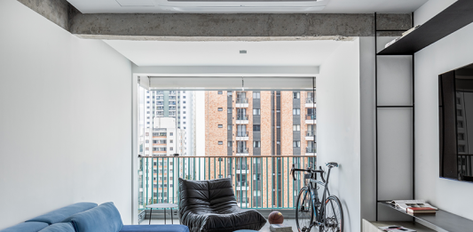 Tons de cinza e serralheria inteligente coroam apartamento atemporal em Moema Projeto: Natália Minas e Gabriela Mestriner | Sala integrada com a sacada dando mais amplitude para o ambiente