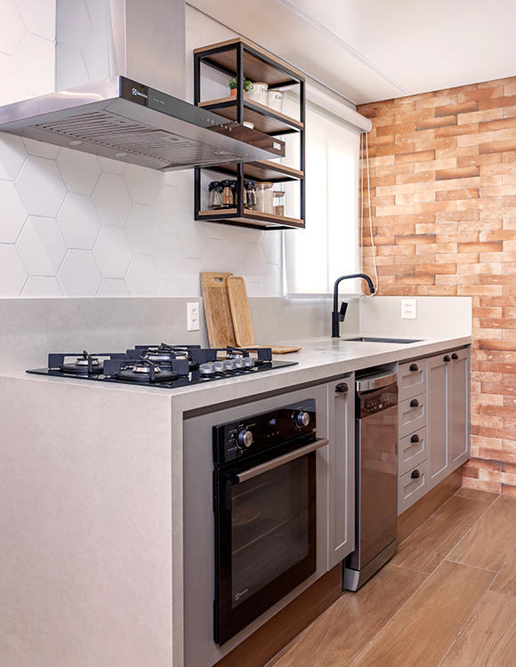 A arquiteta Cristiane Schiavoni selecionou objetos decorativos de cerâmica, em tons de terracota, para promover essa atmosfera natural da cozinha. Ao lado do cooktop, ela uniu a estética ao funcional ao projetar uma estante para os temperos 