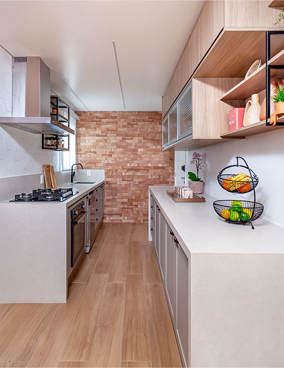 A arquiteta Cristiane Schiavoni selecionou objetos decorativos de cerâmica, em tons de terracota, para promover essa atmosfera natural da cozinha. Ao lado do cooktop, ela uniu a estética ao funcional ao projetar uma estante para os temperos 