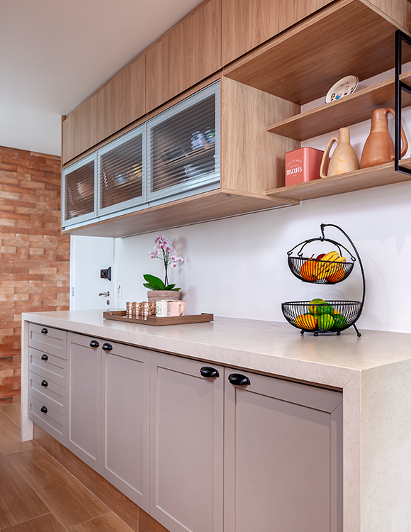 A arquiteta Cristiane Schiavoni selecionou objetos decorativos de cerâmica, em tons de terracota, para promover essa atmosfera natural da cozinha. Ao lado do cooktop, ela uniu a estética ao funcional ao projetar uma estante para os temperos