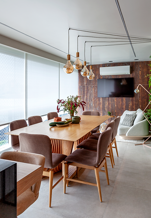 A mesa de jantar acomoda até oito pessoas e é acompanhada por cadeiras com acabamento aveludado no tom mocha mousse – eleito pela Pantone como cor de 2025 | Projeto: Cristiane Schiavoni Arquitetura e Interiores