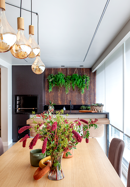 A mesa de jantar acomoda até oito pessoas e é acompanhada por cadeiras com acabamento aveludado no tom mocha mousse – eleito pela Pantone como cor de 2025 | Projeto: Cristiane Schiavoni Arquitetura e Interiores