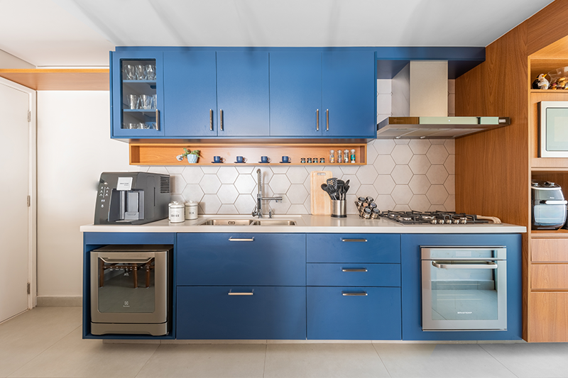 Com atmosfera acolhedora, esta cozinha azul projetada por Bruno Moraes combina o estilo retrô e contemporâneo em um espaço de convívio. Projeto BMA Studio