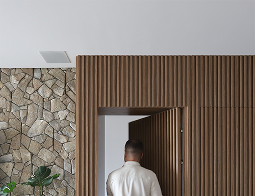 Portas mimetizadas: integração e fluidez nos projetos arquitetônicos Camuflada no painel ripado, a portas mimetizadas concebidas pelo arquiteto Bruno Moraes resguardam a entrada do lavabo e do dormitório