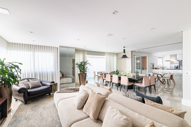 Living, sala de jantar e cozinha são integrados. Para completar, ao fundo, apenas um porta de vidro de correr faz a separação com a varanda gourmet, tornando o ambiente propício para reuniões e festas, devido à fácil circulação | Projeto de Isabella Nalon
