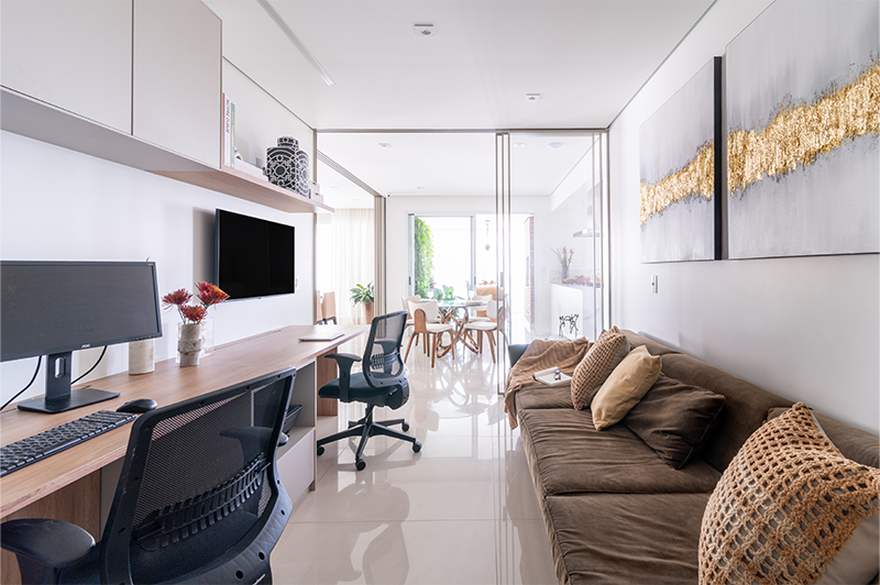 O home-office do casal possui uma ampla bancada divisão de ambientes pela porta de correr | Projeto:Isabella Nalon