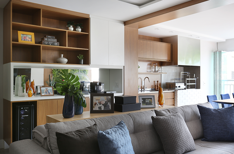 Projeto: RMV Interiores | Integração com varanda e ilha na cozinha ampliam e conectam os ambientes, enquanto a paleta neutra com azul valoriza a frente do apartamento.
