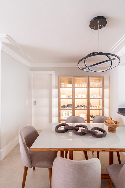 Projeto: Isabella Nalon, produção Coletivo Borogodo| As imagens evidenciam a integração entre sala de estar, jantar e cozinha em conceito aberto, com destaque para a cristaleira clean e discreta, que une estética e funcionalidade ao facilitar o acesso às louças.