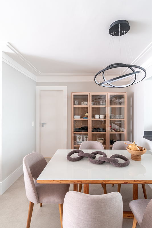 Projeto: Isabella Nalon, produção Coletivo Borogodo| As imagens evidenciam a integração entre sala de estar, jantar e cozinha em conceito aberto, com destaque para a cristaleira clean e discreta, que une estética e funcionalidade ao facilitar o acesso às louças.