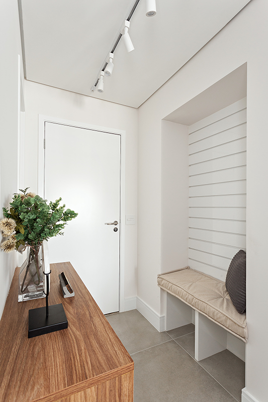 Projeto: RMV Interiores | Hall com banco embutido acolhe na entrada, enquanto o living aposta em tons suaves, conforto e paisagismo leve.
