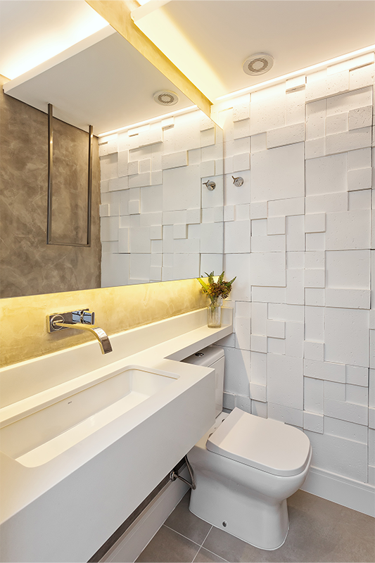 Projeto: RMV Interiores | No lavabo, cimento queimado, revestimento 3D e suporte de toalha em serralheria criam um ambiente urbano e ousado, com iluminação difusa.