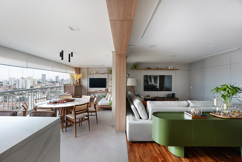 Projeto: Rosangela Pena Arquitetura | Entre a sala de estar e a varanda, a arquiteta Rosangela Pena valorizou a viga existente ao revesti-la com madeira. A 'divisão' sutil entre os ambientes tornou-se ainda mais elegante.