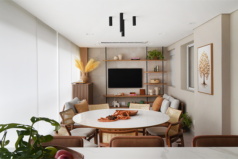 Projeto: Rosangela Pena Arquitetura | Na intersecção invisível entre o gourmet e a espécie de sala íntima formada na outra ponta da varanda, a mesa redonda foi complementada pela naturalidade da palhinha evidente no encosto das cadeiras.