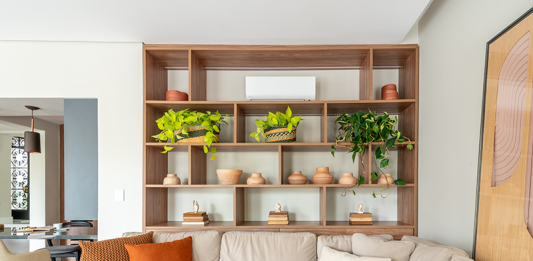 Como integrar o ar-condicionado no décor Projeto: Isabella Nalon | Neste ambiente, o ar-condicionado foi discretamente integrado ao nicho superior da estante. A composição com elementos decorativos suaviza sua presença e harmoniza o equipamento ao décor