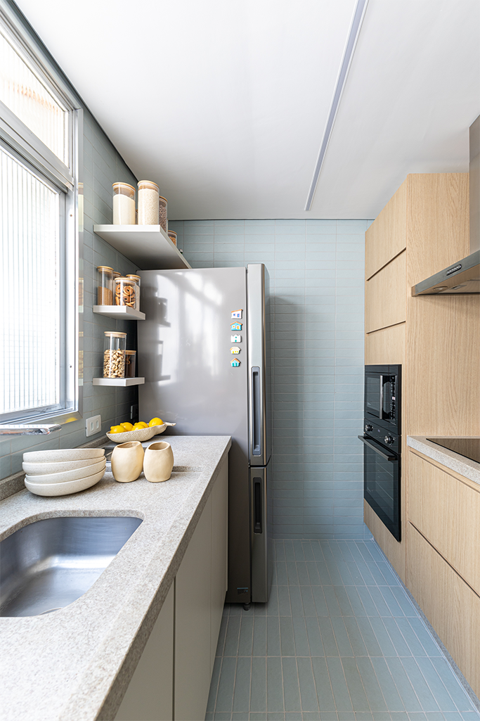 Projeto: Bima Arquitetura | A cozinha com novo layout reorganiza os ambientes, inserindo a lavanderia oculta dentro de um armário.