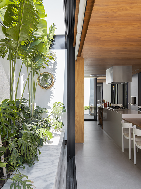 Projeto: Rodolfo Fontana | Cozinha gourmet envidraçada se integra ao jardim e ao interior da casa, funcionando como elo entre os espaços e protagonizando o novo layout.