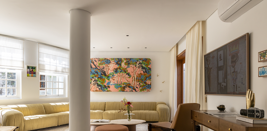 Memórias e aconchego na casa de Isabella Scherer e Rodrigo Calazans, por Fatta Arquitetura Projeto: Fatta Arquitetura | A sala ampla com mobiliário em madeira é um verdadeiro museu com objetos de viagens, telas feitas pelas crianças e peças de design modernas de artistas conceituados.
