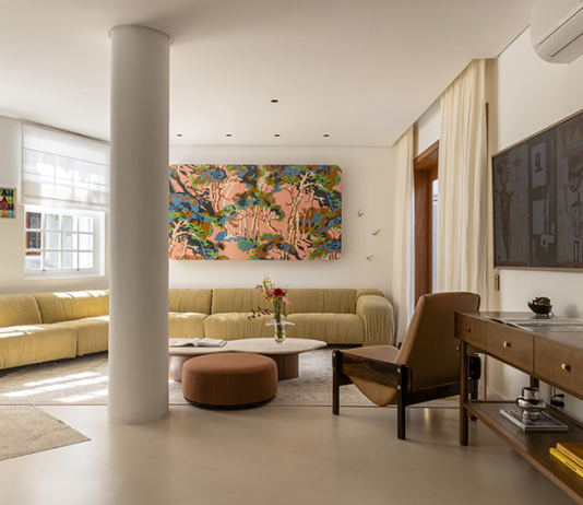 Memórias e aconchego na casa de Isabella Scherer e Rodrigo Calazans, por Fatta Arquitetura Projeto: Fatta Arquitetura | A sala ampla com mobiliário em madeira é um verdadeiro museu com objetos de viagens, telas feitas pelas crianças e peças de design modernas de artistas conceituados.