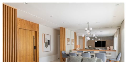 STAL Arquitetura assina renovação de apartamento na Vila Andrade Projeto: Stal Arquitetura|Painéis ripados em freijó disfarçam portas e integram a entrada à área social, conferindo elegância e unidade visual.