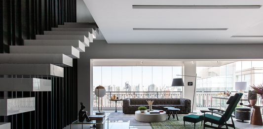 Cobertura duplex na Aclimação ganha projeto que alia sofisticação, lazer e funcionalidade Projeto: Daiane Antinolfi | Composição sofisticada no living, que combina sofás claros, detalhes em murano e flores, equilibrando conforto e elegância.