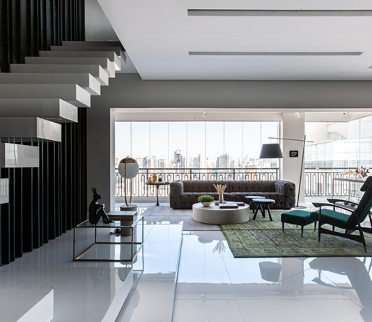 Cobertura duplex na Aclimação ganha projeto que alia sofisticação, lazer e funcionalidade Projeto: Daiane Antinolfi | Composição sofisticada no living, que combina sofás claros, detalhes em murano e flores, equilibrando conforto e elegância.
