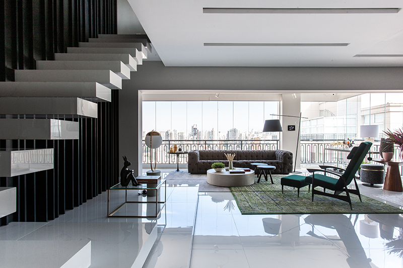 Projeto: Daiane Antinolfi | Composição sofisticada no living, que combina sofás claros, detalhes em murano e flores, equilibrando conforto e elegância.