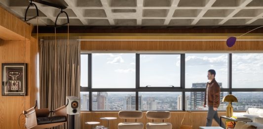 Rodolfo Fontana assina projeto que une estética industrial e conforto em amplo apartamento de 280 m² Projeto: Rodolfo Fontana | A área social do Apartamento Mike combina a imponência da laje aparente com mobiliário contemporâneo e vistas panorâmicas da cidade, em um espaço que equilibra linguagem industrial e conforto.