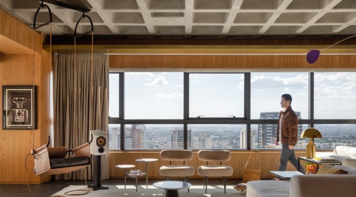 Rodolfo Fontana assina projeto que une estética industrial e conforto em amplo apartamento de 280 m² Projeto: Rodolfo Fontana | A área social do Apartamento Mike combina a imponência da laje aparente com mobiliário contemporâneo e vistas panorâmicas da cidade, em um espaço que equilibra linguagem industrial e conforto.