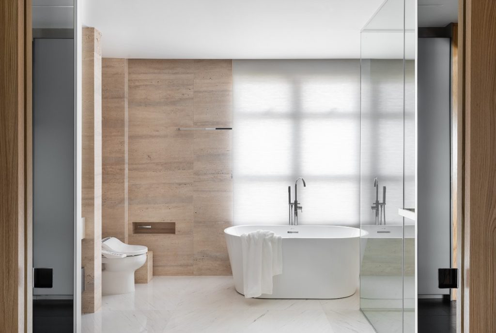 Projeto: Rodolfo Fontana | No banheiro, o mármore claro e a banheira de design clean criam uma atmosfera de elegância e relaxamento.