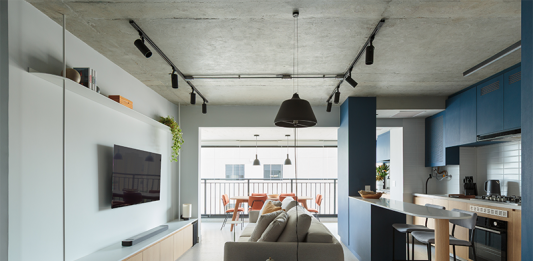 Estilo industrial, cor e integração marcam o Apartamento RB, assinado pelo Estúdio Maré Projeto: Estúdio Maré | Integração entre sala, cozinha e varanda valoriza a entrada de luz natural e amplia a sensação de espaço.
