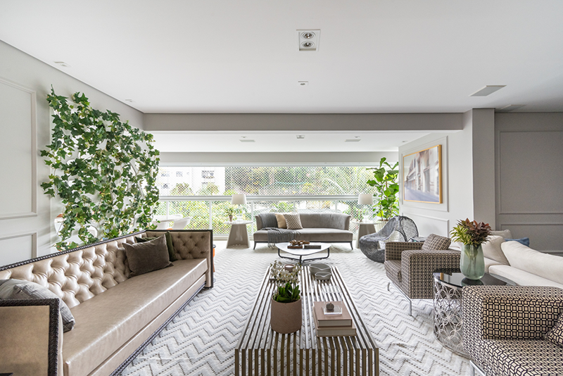 Projeto: Sabrina Salles | O sofá-ilha contemporâneo, com braços em madeira que funcionam como mesa lateral, garante fluidez e integração entre os ambientes sociais.