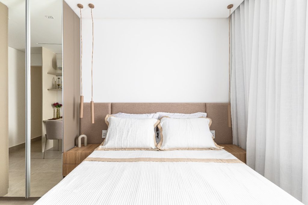 Projeto: Bimá Arquitetura | A suíte do casal equilibra marcenaria com uma cabeceira estofada. 