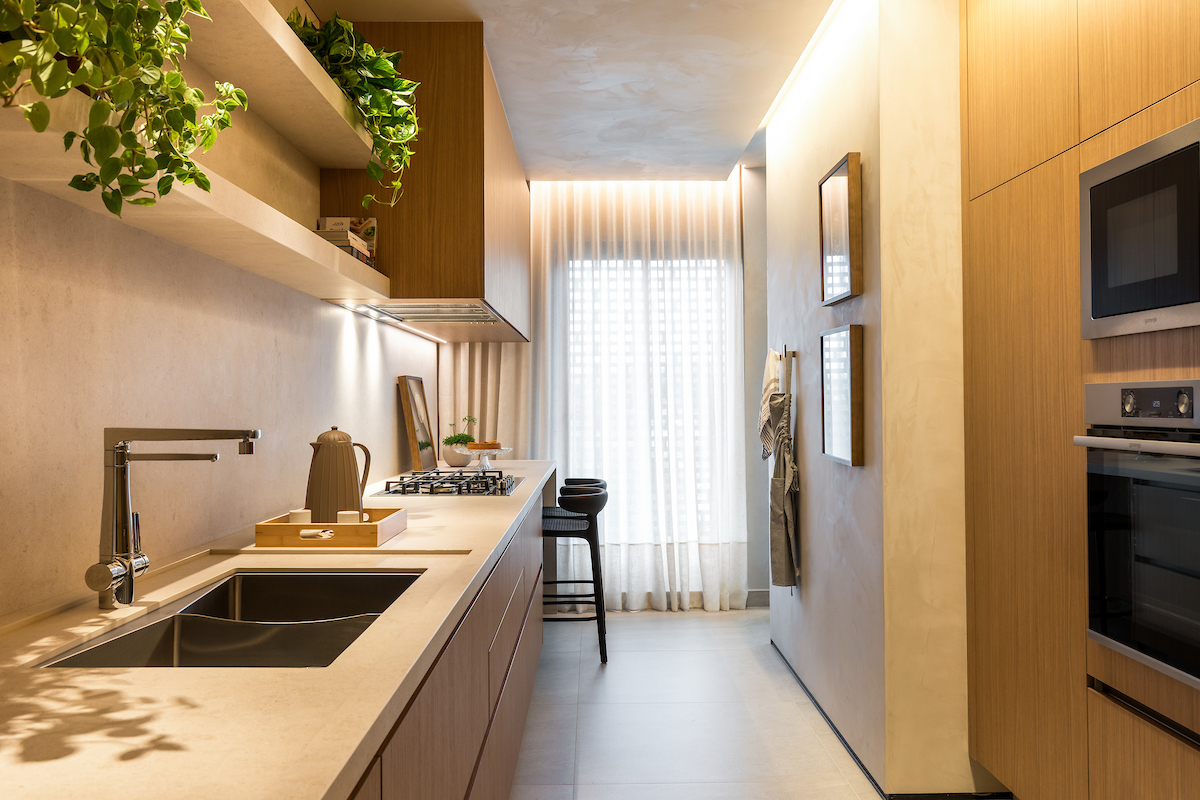 Projeto: Bo.arch Studio | Com marcenaria em tons amadeirados, iluminação linear e acabamentos neutros, a cozinha alia estética minimalista e praticidade no dia a dia da família.