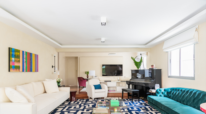 Entre cores, formas e boas vibrações: Juliana Fabrizzi comanda projeto para jovem família Projeto: Juliana Fabrizzi | Cores e formas em harmonia: o sofá azul-turquesa, o piano e a mesa lateral vermelha trazem energia e personalidade ao ambiente.