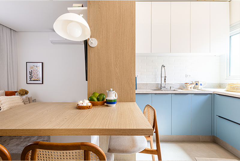 Projeto: Bimá Arquitetura | O painel em madeira cria uma sutil divisão entre a sala de jantar e a cozinha, garantindo privacidade sem comprometer a integração dos ambientes