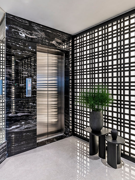 Projeto: Érica Salguero | Logo na entrada, um hall de impacto recebe os moradores com um mármore exótico e marcenaria sob medida, que já anunciam o tom sofisticado do restante do projeto.