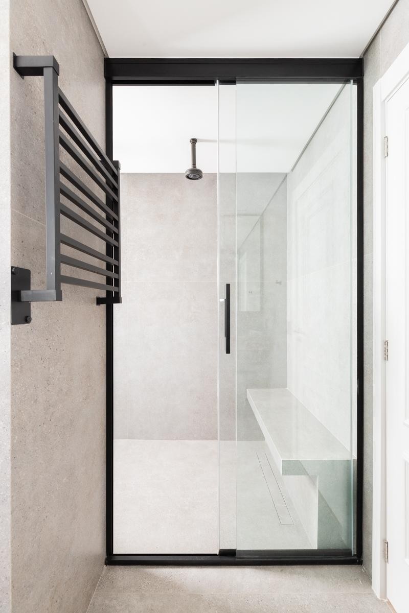 Projeto: Sabrina Salles | Atmosfera de spa, luz suave e detalhes sofisticados — o banheiro da suíte combina elegância e atemporalidade.