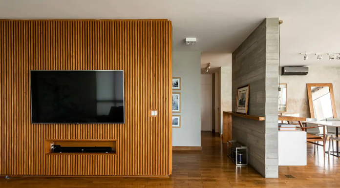 Painel ripado: descubra vantagens e 6 formas de transformar ambientes Ripado transforma a parede da TV em ponto central – Foto: Pedro Mascaro/CASACOR | Projeto: Helô Marques Arquitetura