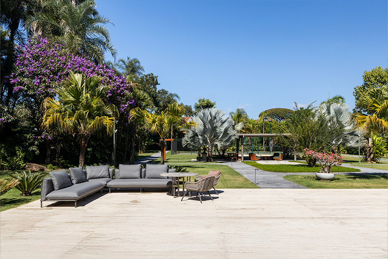 Diferentes cores, alturas e texturas de espécies compõem o jardim com piscina e área de convivência.