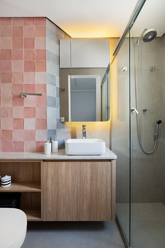 Projeto: Studio Monfré | O banheiro recebeu azulejos em tons de rosa combinando perfeitamente com o revestimento cinza escolhido para o piso