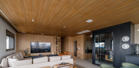 Integração e adega walk-in marcam projeto contemporâneo em apê de 180m² Projeto: Yannick Athia | Sala de jantar conectada à área social, destacando móveis com tampos orgânicos e a atmosfera acolhedora criada pela marcenaria em madeira.
