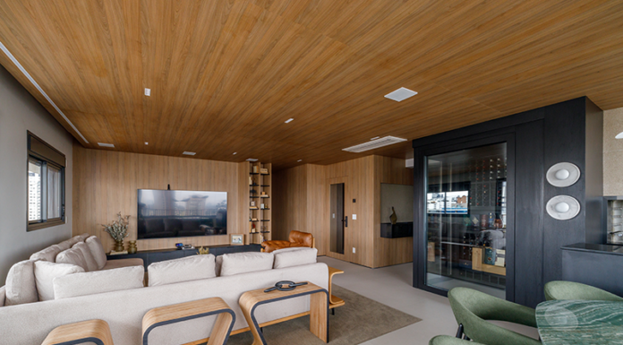 Integração e adega walk-in marcam projeto contemporâneo em apê de 180m² Projeto: Yannick Athia | Sala de jantar conectada à área social, destacando móveis com tampos orgânicos e a atmosfera acolhedora criada pela marcenaria em madeira.