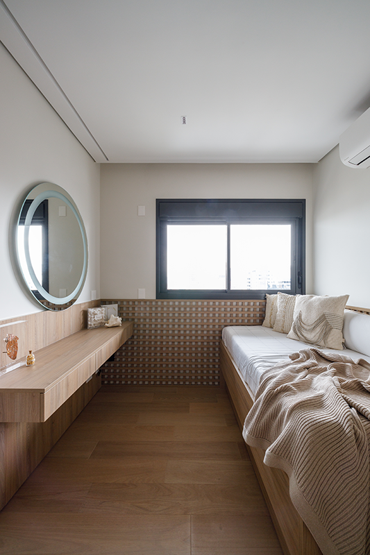 Projeto: Yannick Athia | No quarto das filhas, a arquiteta utilizou uma marcenaria delicada, penteadeira com espelho iluminado e acabamentos suaves que reforçam o aconchego.