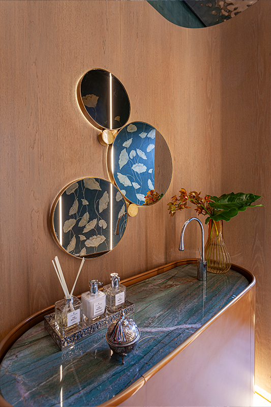 Projeto: BZP Arquitetura | Lavabo com teto em inox “water ripple”, pintura artística e painéis curvos de madeira, traduzindo sofisticação e personalidade.