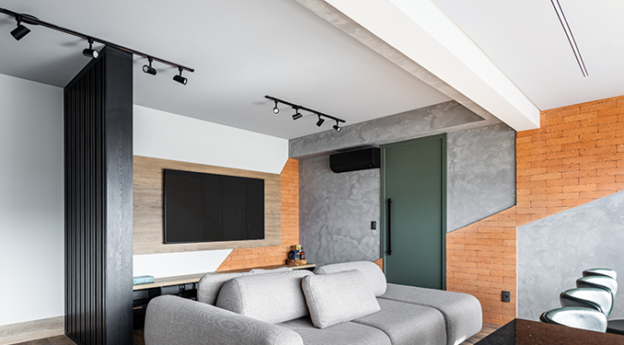 Elegância urbana em apartamento de 90m² no Morumbi Projeto: Camila Palladino| O hall de entrada com luz lateral e divisória em madeira preta que introduz a paleta urbana e sofisticada do projeto ao entrar na sala.