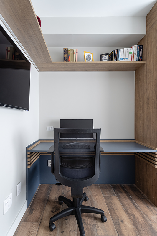 Projeto: Camila Palladino| Suíte funcional com home office: marcenaria contínua organiza bancada, armários e nichos; paleta em azul profundo, cinza e branco traz leveza e foco.