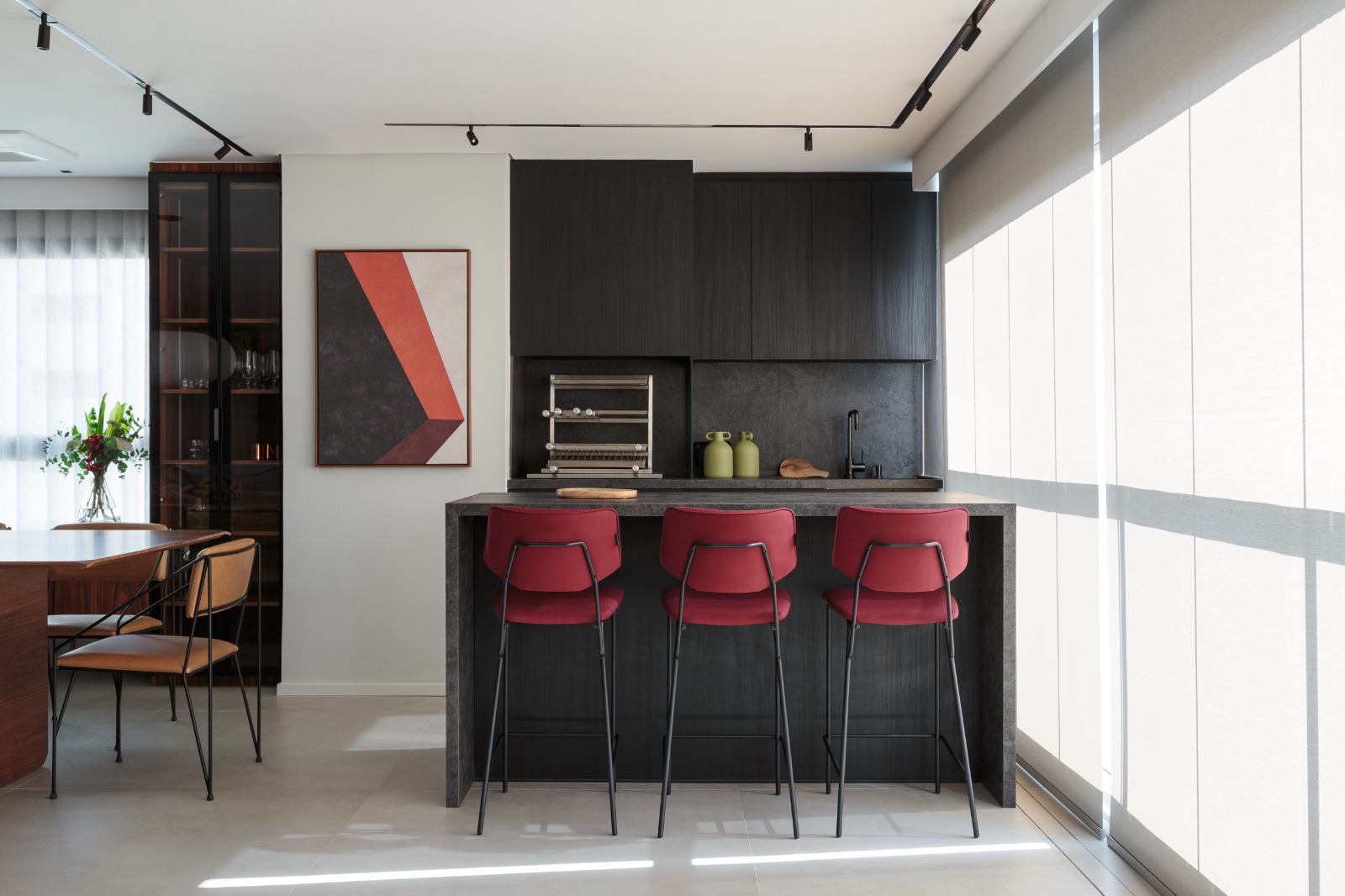 Projeto: Estúdio Maré| Sala integrada à varanda, marcada por luz natural abundante e painéis em MDF ebanizado. A marcenaria sob medida e as peças de design pontuais criam uma atmosfera sofisticada e acolhedora