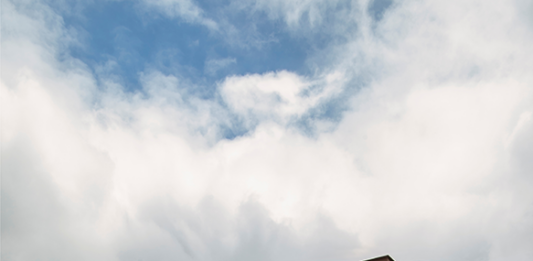 Casa colonial renasce como lar contemporâneo em meio ao verde da serra Projeto: Felipe Rohen Arquitetura | Antes e depois da fachada: a antiga construção colonial de tijolinhos deu lugar a uma nova linguagem contemporânea, marcada por linhas retas, pedras naturais e portas em azul vibrante.