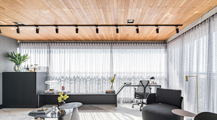 Trabalhar em casa: home office como protagonista Com grande demanda de uso, este home office foi constituído como um cômodo independente, embora esteja presente na varanda, integrado com a sala.