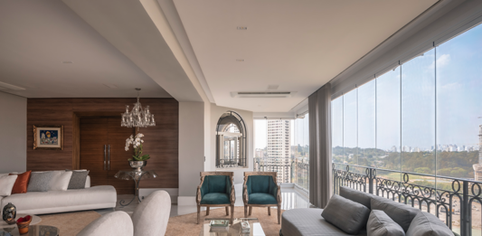 Eliana Tucci reforma apartamento com 300m² e área social totalmente integrada No projeto, a varanda integrada ao living com envidraçamento automatizado, valoriza a vista, garante conforto acústico e amplia a área social